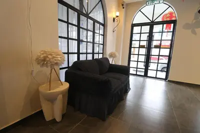 a living room with a chair and a large window at Casa Colney Hotel Ipoh in Ipoh
