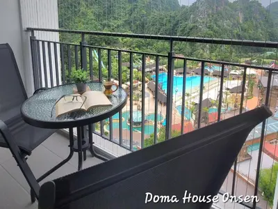 a balcony with a table and a view of a pool at Doma House Onsen at Sunway Onsen, Tambun in Ipoh