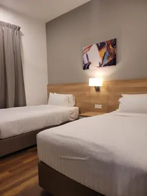 a hotel room with two beds and a lamp at Doma House Onsen at Sunway Onsen, Tambun in Ipoh