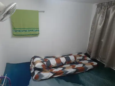 a pillow sitting on a bed next to a window at DIAMOND HOMESTAY in Kuala Kangsar