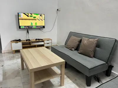 a living room with a couch and a tv at Near 7ELEVE KFC 10pax 3BR Hutan Melintang by willz in Hutan Melintang