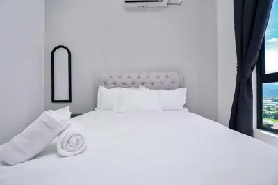 a white bed with white pillows and a window at Ben Cozy Executive Suite 3BR The Horizon Ipoh in Ipoh