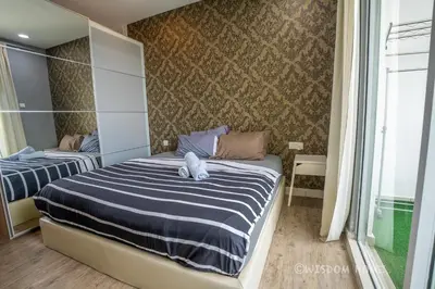 a bedroom with a bed with a blue and white striped sheets at Georgetown Seaview MansionOne @Penang in George Town