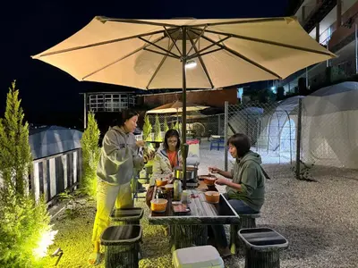 a group of people sitting at a table under an umbrella at Gold Crest Cameron Highlands in Tanah Rata
