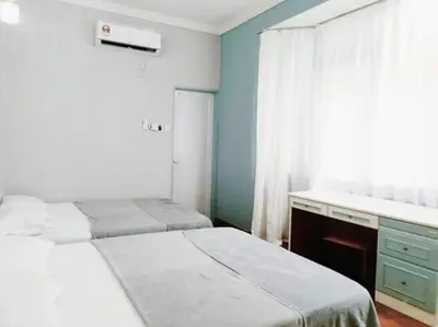 a bedroom with two beds and a desk and a window at HT Homestay BigSemi-D BBQwedding in town in Jelutong