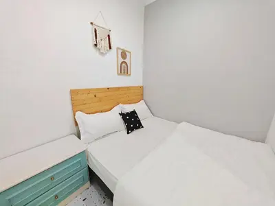 a bedroom with two beds and a wooden headboard at HT Homestay BigSemi-D BBQwedding in town in Jelutong