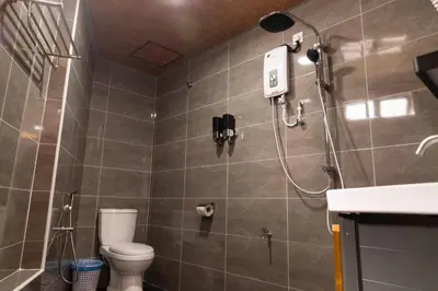 a bathroom with a shower with a toilet and a sink at Sunrisestay in Brinchang