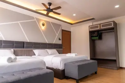 a bedroom with two beds and a ceiling fan at Sunrisestay in Brinchang
