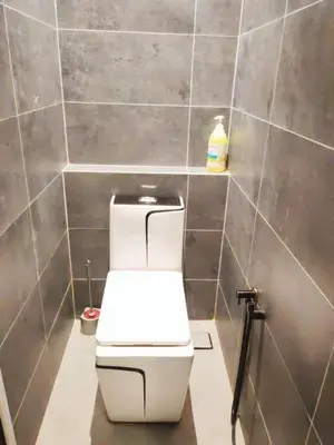 a bathroom with a white toilet in a tile wall at 12 George town 6room terrace gurney heritage adventist hospital restaurant shopping mall in George Town