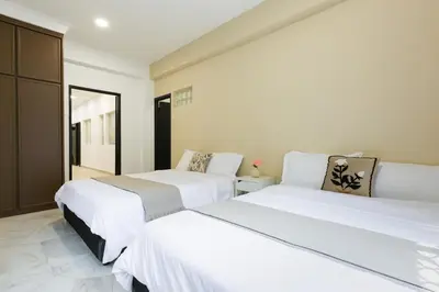 two beds in a room with white walls at 35 Home4Stay Tanjong Bungalow Wedding BBQ Near Beach restaurant in Tanjung Bungah