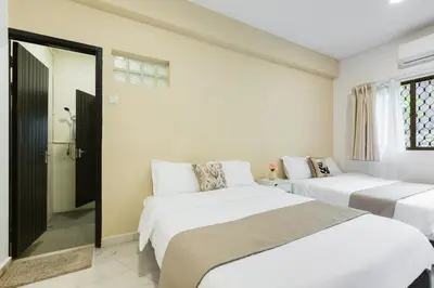 two beds in a room with white walls at 35 Home4Stay Tanjong Bungalow Wedding BBQ Near Beach restaurant in Tanjung Bungah