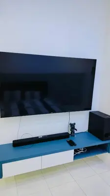 a large flat screen tv sitting on top of a table at Nyaman Sweet Home in Balik Pulau