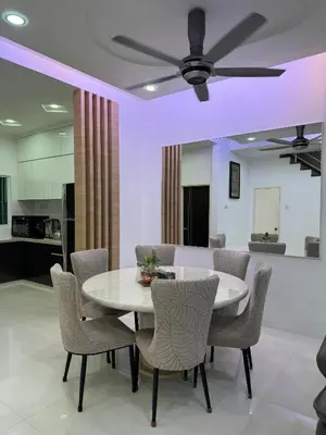 a dining room with a white table and chairs at Nyaman Sweet Home in Balik Pulau