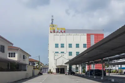 a white building with a tower on top of it at Hotel O Bei King in Sitiawan