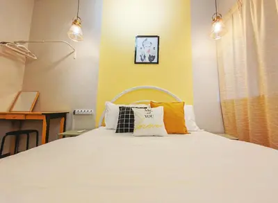 a bedroom with a bed with orange and white pillows at 7 Home4Stay Peaceful GurneyTerrace 4BR15pax Shops & Eateries in George Town