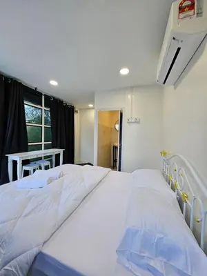 a large white bed in a room with a table at Sentosa Palace in Dabung