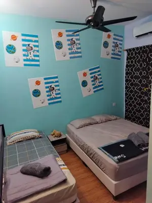 two beds in a room with posters on the wall at Idea Homestay 1 in Chemor