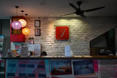 a restaurant with a ceiling fan on a brick wall at Hotel Jelai @ Raub, Pahang in Raub