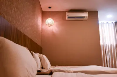 a hotel room with two beds and a light at Hotel Jelai @ Raub, Pahang in Raub