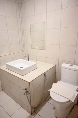 a white bathroom with a sink and a toilet at Hotel Jelai @ Raub, Pahang in Raub