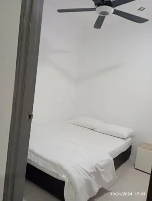 a white bed with a ceiling fan in a room at 3R Guest House Manhattan Condominium in Ipoh