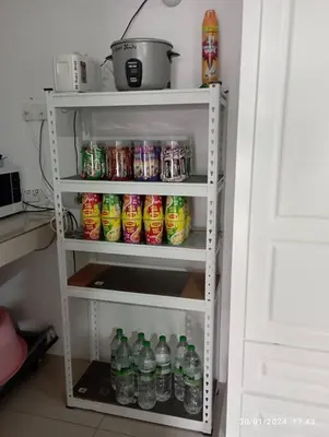 a white shelf with soda cans and soda bottles at 3R Guest House Manhattan Condominium in Ipoh