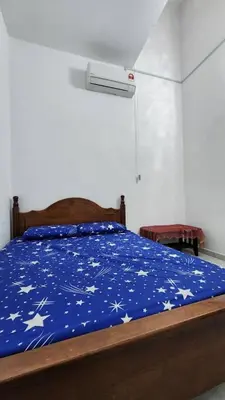 a bed with a blue comforter with stars on it at Masturi Homestay in Chemor