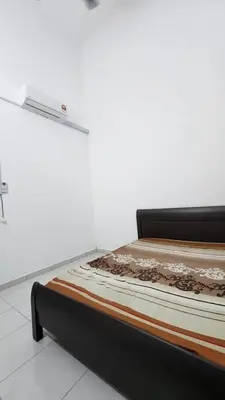 a bed in a room next to a wall at Masturi Homestay in Chemor