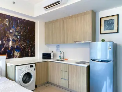 a kitchen with a refrigerator and a washing machine at Tropicana 218 Macalister by YueLai Inn in George Town