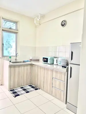a kitchen with a sink and a refrigerator at Arena Spice Guesthouse in Bayan Lepas