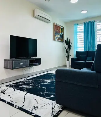 a living room with a tv and a blue couch at Arena Spice Guesthouse in Bayan Lepas