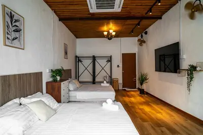 two beds in a large room with wooden ceilings at Caryn Vintage Guesthouse in George Town