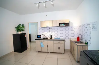 a kitchen with wooden cabinets and a black refrigerator at Seaview mansion one Georgetown Penang in George Town