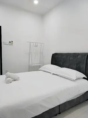 a white bed with a black headboard and white pillows at 13Pax -2 Storey Bayu Mutiara Bukit Mertajam Penang in Bukit Mertajam
