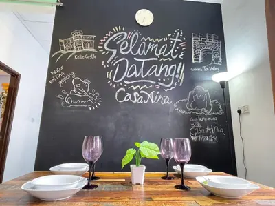 a table with wine glasses and a chalkboard at CASA AINA at Gopeng Cozy & Comfy Home in Kampong Kepayang