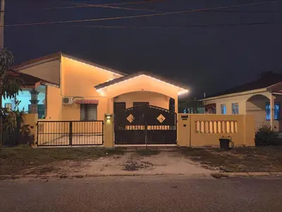 a house with a gate in front of it at night at CASA AINA at Gopeng Cozy & Comfy Home in Kampong Kepayang