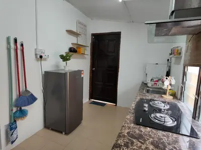 a kitchen with a stove and a refrigerator at CASA AINA at Gopeng Cozy & Comfy Home in Kampong Kepayang