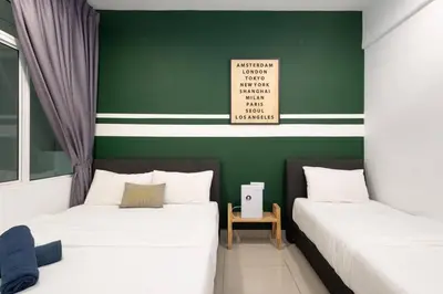 two beds in a room with a green wall at Dream - Summer @Majestic Condo in Ipoh