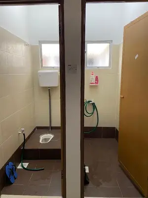 a bathroom with a toilet and a sink in it at EmyNuar Homestay in Batu Kurau