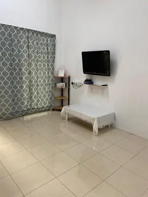 a living room with a tv and a tiled floor at EmyNuar Homestay in Batu Kurau