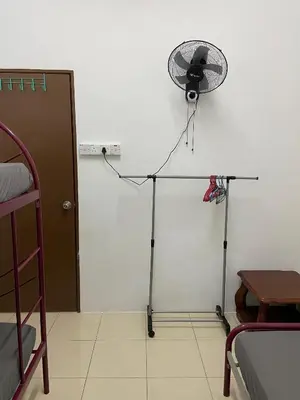 a fan on a tripod in a room at EmyNuar Homestay in Batu Kurau
