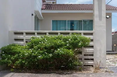 a house with a bush in front of a building at BrandNew Premium House 4Room12Pax@ALMA NEAR JUSCO in Bukit Mertajam