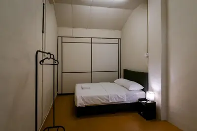 a small room with a bed with white sheets at Aayu Beach St - George Town Penang in George Town
