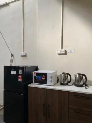 a kitchen with a black refrigerator and a microwave at Aayu Beach St - George Town Penang in George Town