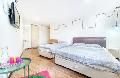 a bedroom with two beds and a table with a tv at Snooze Hotel in Brinchang