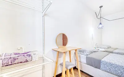 a small bedroom with a bed and a mirror at Snooze Hotel in Brinchang