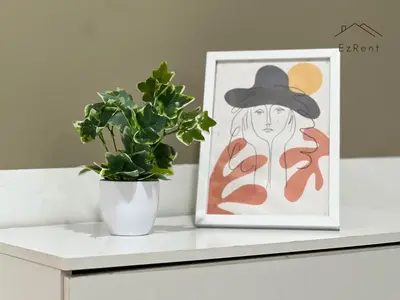 a plant sitting on a table next to a painting at Spacious Family 4BR House near Lake Garden Zoo Taiping with Free WiFi and Netflix in Taiping
