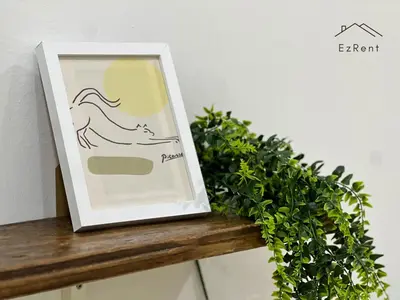 a picture of a cat sitting on a table with a plant at Spacious Family 4BR House near Lake Garden Zoo Taiping with Free WiFi and Netflix in Taiping