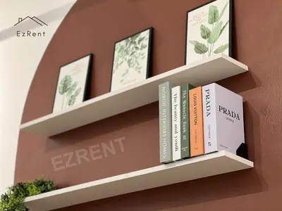 a shelf with books and pictures on a wall at Spacious Family 4BR House near Lake Garden Zoo Taiping with Free WiFi and Netflix in Taiping