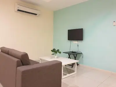 a living room with a couch and a tv and a table at Marina Island Seaview Homestay in Lumut